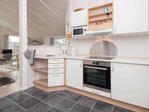 Flovtにある6 person holiday home in Haderslevのキッチン(白いキャビネット、コンロ付)