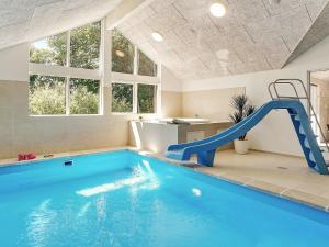 a indoor swimming pool with a slide in a house at 18 person holiday home in Hasselberg in Kappeln