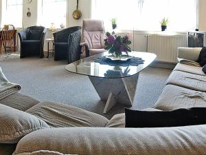 ヴィデ・サンデにある6 person holiday home in Hvide Sandeのリビングルーム(ガラスのテーブル、椅子付)