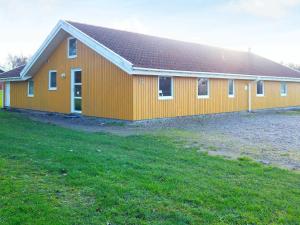 ノーポにある12 person holiday home in Nordborgの前方に芝生の畑がある大きなオレンジ色の建物