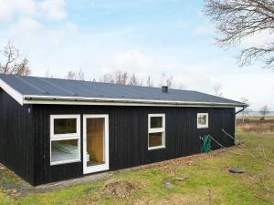 Ørstedにある10 person holiday home in rstedの白窓と屋根の黒い家