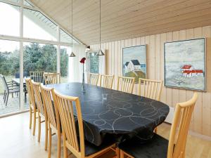 une salle à manger avec une table et des chaises noires dans l'établissement Holiday home Løkken XXIV, à Løkken