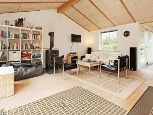 a living room with a couch and a table and chairs at 6 person holiday home in Dronningm lle in Dronningmølle