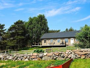 una casa con una pared de piedra delante de ella en 6 person holiday home in VAREKIL en Varekil