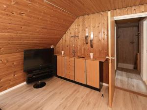 3 person holiday home in Ansager في Ansager: غرفة معيشة فيها تلفزيون وجدار خشبي