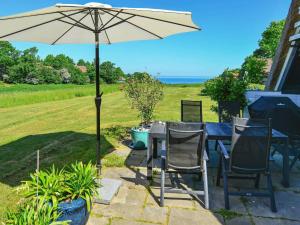 a table and chairs with an umbrella on a patio at 6 person holiday home in Asperup in Asperup