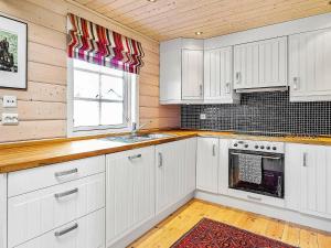 a kitchen with white cabinets and a window at 10 person holiday home in SERAL in Åseral