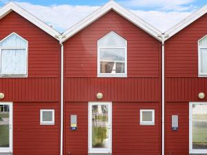 a red house with white windows on it at Apartment Hadsund in Øster Hurup