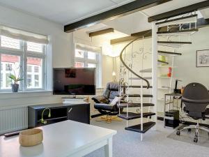 uma sala de estar com uma escada em espiral e uma secretária em 5 person holiday home in R nne em Rønne