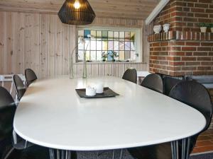 una gran mesa blanca en una habitación con sillas en Holiday Home Lappedykkervej en Egense