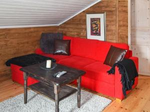 a red couch in a living room with a table at 10 person holiday home in SERAL in Åseral