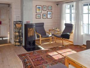 a living room with a wood stove and two chairs at 10 person holiday home in SERAL in Åseral