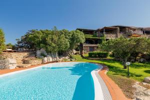 una piscina en un patio con árboles y un edificio en Villa Romantica, en Olbia