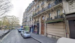 a street with cars parked next to a building at Very large private room with own bathroom, in Montmartre apartment in Paris