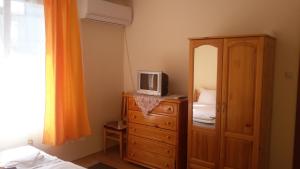 a bedroom with a dresser with a tv on top of it at Къща за почивка Смокиня in Sozopol