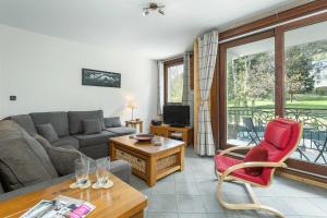 ein Wohnzimmer mit einem Sofa und einem Tisch in der Unterkunft APARTMENT STADDON - Alpes Travel - Central Chamonix - Sleeps 4-6 in Chamonix-Mont-Blanc