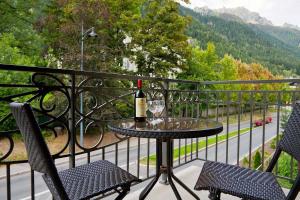 einen Tisch mit einer Flasche Wein und zwei Stühle auf dem Balkon in der Unterkunft APARTMENT STADDON - Alpes Travel - Central Chamonix - Sleeps 4-6 in Chamonix-Mont-Blanc
