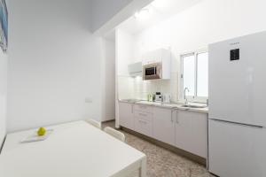 een keuken met witte kasten en een wit aanrecht bij CoolivingC in Las Palmas de Gran Canaria