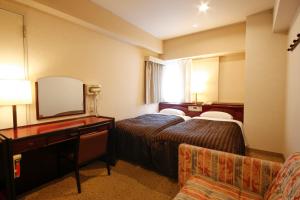 a hotel room with two beds and a mirror at Hotel Sunlife in Osaka