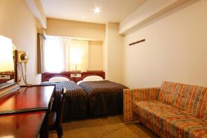 une chambre d'hôtel avec un lit et un canapé dans l'établissement Hotel Sunlife, à Osaka