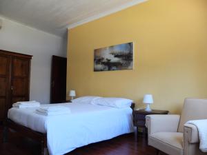 a bedroom with a white bed and a yellow wall at House near Fontelo in Viseu