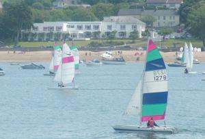 a group of sailboats in the water near a beach at The Commodore Hotel in Instow