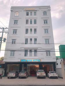 a large white building with cars parked in front of it at Khách sạn SAO NAM in Cao Lãnh