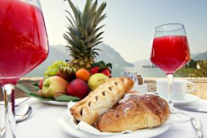 a table with a plate of food and glasses of wine at Hotel Lovere Resort & Spa in Lovere