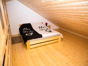 a small room with a bed in a wooden room at Radawa - Domki przy Stadninie in Radawa