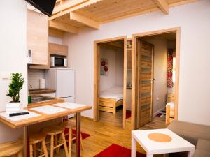 a small apartment with a kitchen and a dining room at Radawa - Domki przy Stadninie in Radawa