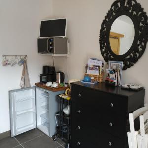 - une chambre avec une commode noire et un miroir dans l'établissement Studio dans les bois, à Blésignac