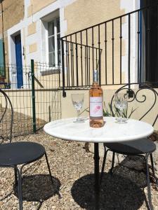una botella de vino sentada en una mesa con dos copas en Gite de Pete, en Le Buisson