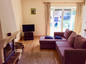a living room with a couch and a tv at Gite de Pete in Le Buisson