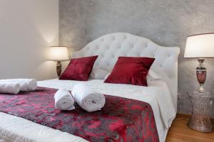 a bedroom with a large white bed with red pillows at Residenza Duomo3 - Apartments in Verona +91 photos