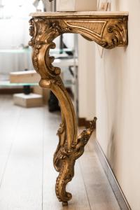 an ornate gold console table with a mirror at Residenza Duomo3 - Apartments in Verona +91 photos