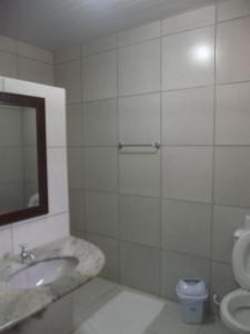 uma casa de banho com um lavatório, um espelho e um WC. em Pousada Max Pomerode em Pomerode