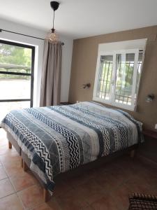ein Schlafzimmer mit einem Bett mit einer Decke darauf in der Unterkunft Finca Mirador in Macastre