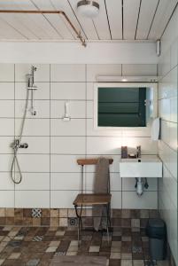 a bathroom with a sink and a chair and a mirror at Mednieki Kalvene in Krusāti