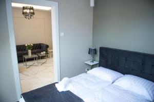 um quarto com uma cama e uma sala de estar em Apartamenty Prestiż 91 em Koszalin