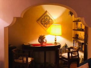 エーリチェにあるLa scalettaのテーブル、ランプ、椅子2脚が備わる客室です。