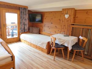 Schlafzimmer mit einem Bett und einem Tisch mit Stühlen in der Unterkunft Haus Marienheim in Heiligenblut
