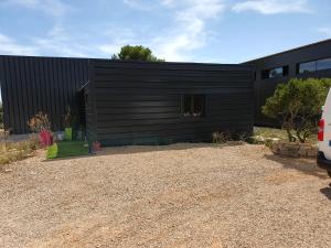 a black house with a gravel driveway at LOFT 3 PERS PROCHE CIRCUIT PAUL RICARD in Signes