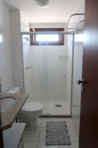 een witte badkamer met een douche en een toilet bij Apartment Terraces Porto Das Baleias in Praia do Forte