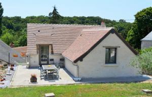 a small white house with a table and chairs at 13 Rue du Perré Maison de vacances in La Membrolle-sur-Choisille