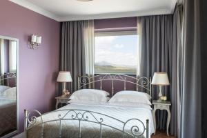 a bedroom with a bed with purple walls and a window at Altarocca Wine Resort Adults Only in Orvieto