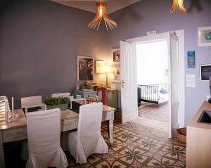 a dining room with a table and white chairs at B&B Porto Trani in Trani