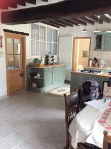 a kitchen with green cabinets and a table in a room at Gite de Pete in Le Buisson