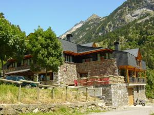 a large stone house in front of a mountain at HOTEL TURPÍ in Benasque