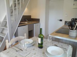 a table with two plates and a bottle of wine at La Petite Tour in Carlux