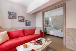 a living room with a red couch and a bedroom at Sweet home apartment in Gaios